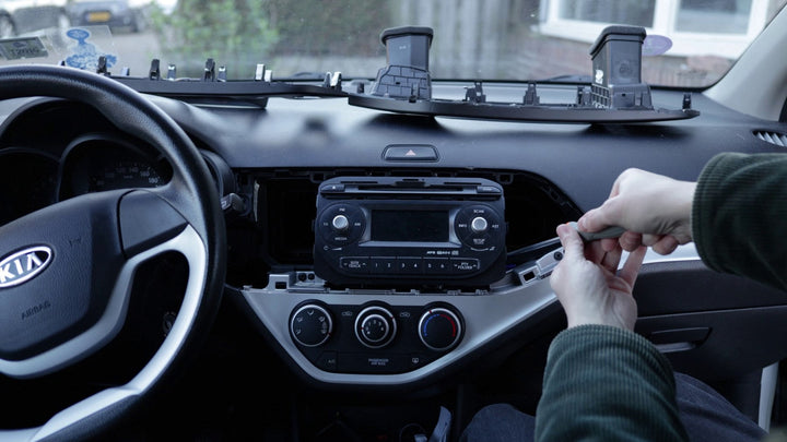 De originele radio van een Kia Picanto wordt losgedraaid om te vervangen